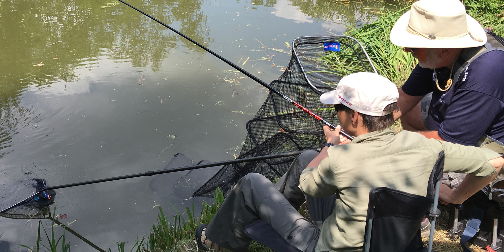 Male and coach coarse fishing at a Get Fishing beginner angling event