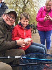 Get Fishing | Spring into Fishing - happy family fishing on a river with a fish